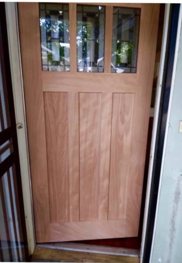 Solid wood front door installation with natural finish