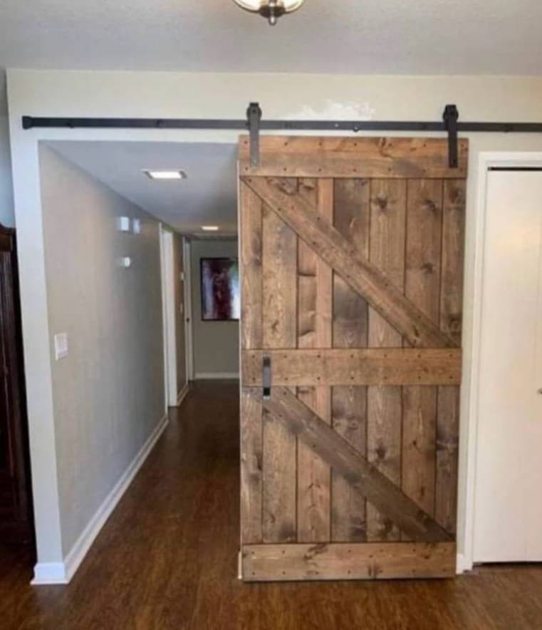 Interior barn door installation with rustic wood sliding hardware